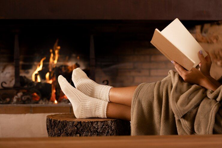 close-up-hands-holding-book-by-the-fire_23-2149172518.jpg